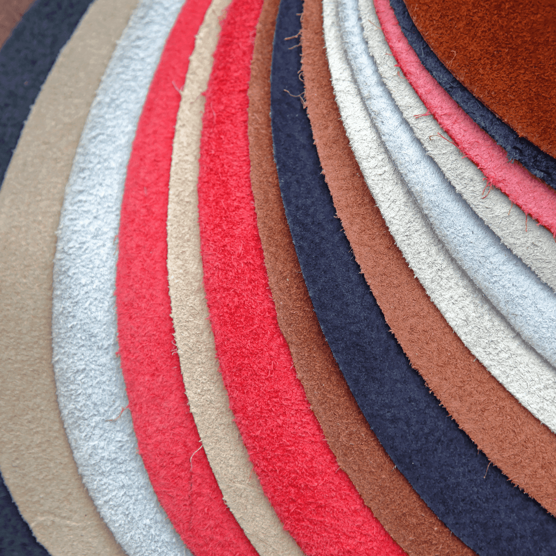 Variety of colored leather swatches showcasing different textures and hues for leather coloring techniques.